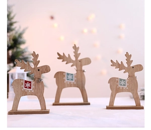 Detailansicht von drei Weihnachts-Rentieren aus Holz mit Schneemustern und Metallglocken
