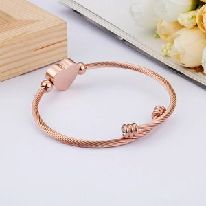 Rose gold twisted cable cuff bracelet with heart charm and sparkling crystal accent