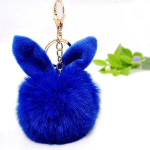 Detailed view of fluffy blue bunny ear pompom keychain with golden metal clasp