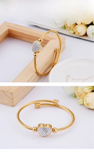 Macro detail of gold steel twisted rope bracelet with a sparkling crystal heart motif