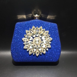 Close-up of a blue evening clutch bag with sparkling finish and large crystal flower decor