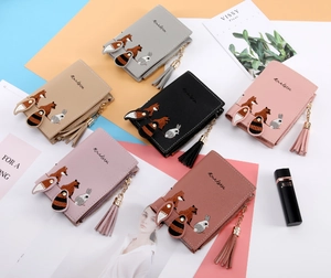 Detailed flat lay of cute embroidered wallets in six colors with decorative tassel zippers