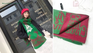 Detail of Christmas knitted scarf with Merry Christmas jacquard and reindeer horn pattern