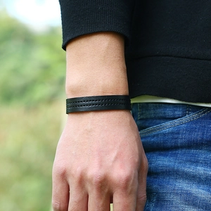 Men's black leather bracelet with double row stitching shown on wrist in natural light