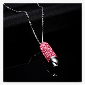 Macro shot of 16mm bullet pendant with pink rhinestones on a silver chain necklace