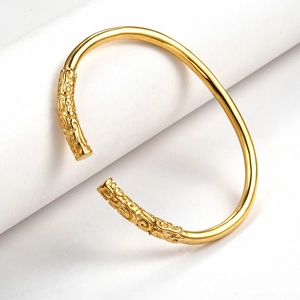 Detailed macro view of gold Ruyi Jingu Bang bracelet with engraved cloud patterns
