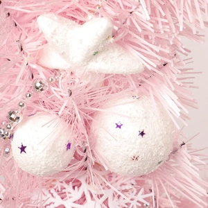 Pink and white Christmas wreath with artificial snowy branches and purple star sequins