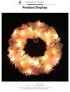Detailed view of pink Christmas wreath with LED lights, frosted balls, and star ornaments