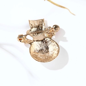 Back view of gold Christmas snowman brooch showing metal texture and safety pin clasp
