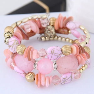 Détail macro du bracelet perles bohème rose et orange avec pierres marbrées dorées