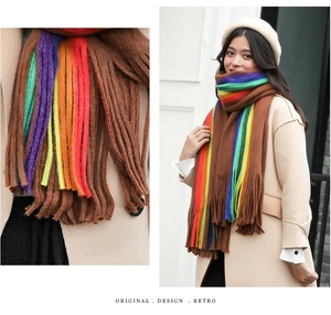 Detail of soft brown cashmere-feel scarf with vibrant rainbow stripes and long tassels