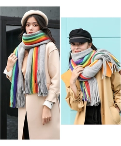 Detail of grey knitted scarf with rainbow stripes and soft tassel fringe for winter warmth
