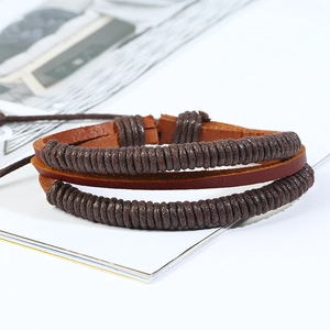 Close-up of multilayer braided leather bracelets in dark brown tones on a white background