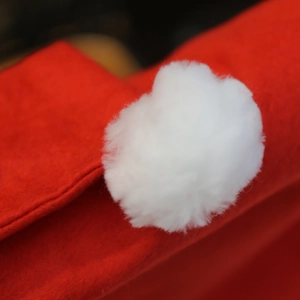 Festive red Christmas chair cover featuring a white plush pompom detail and soft texture