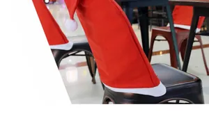 Detail of red Santa hat chair covers with white plush pom-pom for festive dining decor