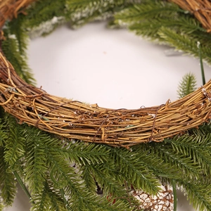 Christmas wreath with green pine needles, brown pine cones and artificial white snow flocking