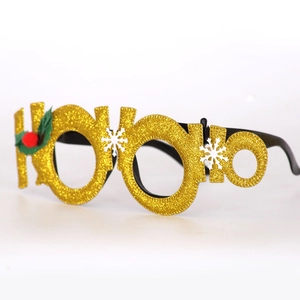 Detail of gold glitter HO HO HO Christmas glasses with holly leaf and snowflake motifs