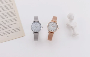 Detailed macro shot of silver and rose gold mesh strap watches with marble texture dials