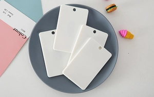 Close-up of blank white ABS plastic ID card holders with pre-punched hanging holes