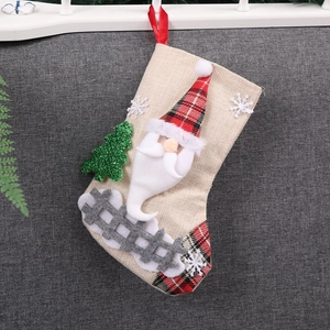 Linen Christmas stocking with Santa Claus and sequined tree decor hanging on rope