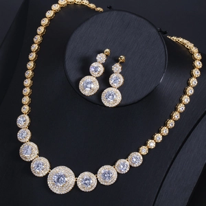 Close-up of golden bridal jewelry set featuring shimmering zircon necklace and drop earrings