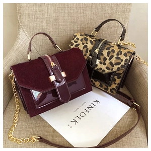 Close-up of leopard print and burgundy wine crossbody bags with gold chain details