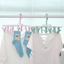 Detail of pink and green plastic laundry drying racks with multiple clips for socks and towels