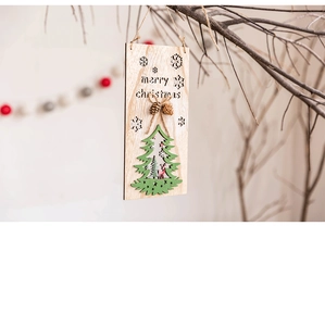 Close-up of wooden Merry Christmas ornament with 3D green tree and pine cone