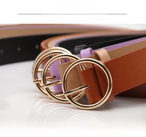 Detail view of stylish alloy round buckles on colorful leather belts for women