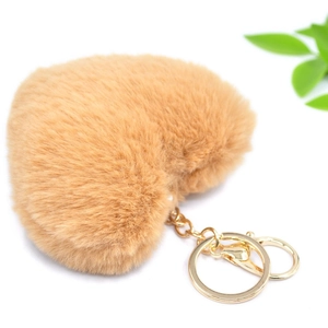 Detalle de llavero de peluche suave en forma de corazón con herrajes dorados