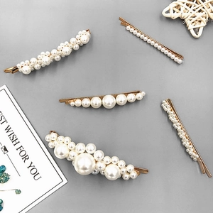 Close-up of a 5-piece gold alloy and white pearl hair clip set on a clean grey background