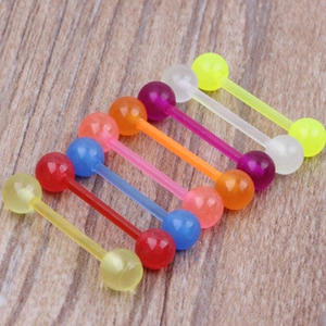 Bunte Zungenpiercings aus Acryl auf Holzoberfläche mit leuchtenden Neonfarben