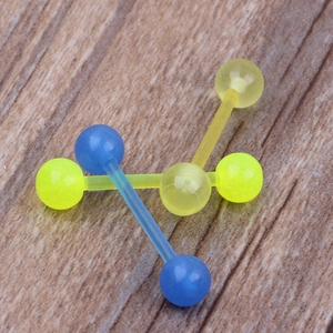 Nahaufnahme von lichtdurchlässigen Acryl-Zungenpiercings in Blau, Grün und Gelb auf Holz