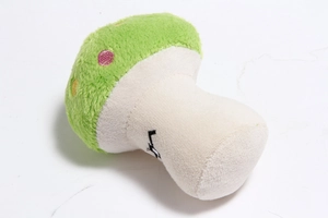 Detailed close-up of a green mushroom plush toy with colorful polka dot embroidery