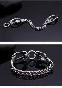 Macro detail of gothic skull charms and chunky link chain on a punk steel bracelet