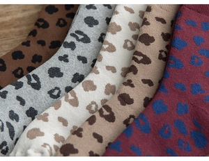 Detail of five pairs of thick leopard print knit socks in various warm earth tones