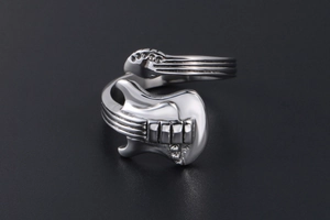 Detailed close-up of a vintage silver guitar ring with intricate fretboard and string details