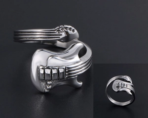 Macro detail of silver guitar-shaped ring with engraved strings and adjustable band