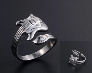 Macro detail of adjustable silver guitar ring with intricate neck and string engravings