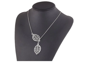 Detail of silver double leaf pendant necklace displayed on a black neck bust model