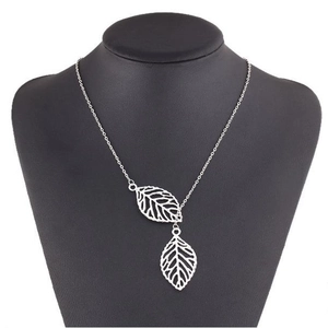 Elegant silver double leaf pendant necklace displayed on a black jewelry bust stand