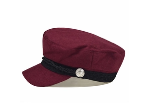 Detail of burgundy wool military cap featuring a black braided strap and silver anchor button