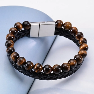 Macro detail of men's double-layer tiger eye stone beads and black braided leather bracelet