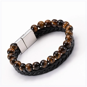 Detailed close-up of tiger eye stone beads and black braided leather with magnetic clasp