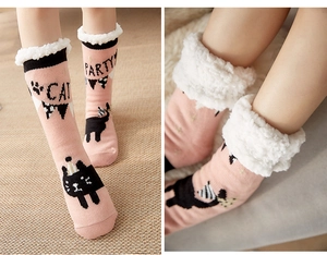 Detail view of pink fleece home socks with cat pattern and plush white cuffs