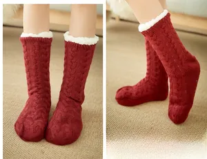 Close-up of wine red cable knit floor socks with thick white sherpa lining and anti-slip grips