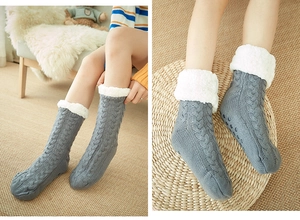Detail of gray cable-knit thermal socks with thick white fleece lining and anti-slip soles