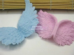 Close-up of pink and blue plastic angel wings with detailed feather texture for DIY