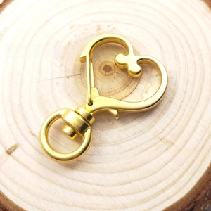 Nahaufnahme des goldenen herzförmigen Karabinerverschlusses mit Wirbelring