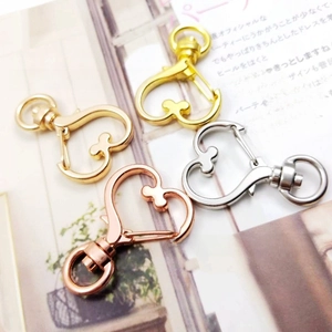 Detail von herzförmigen Karabinerverschlüssen in Gold, Silber und Roségold-Finish